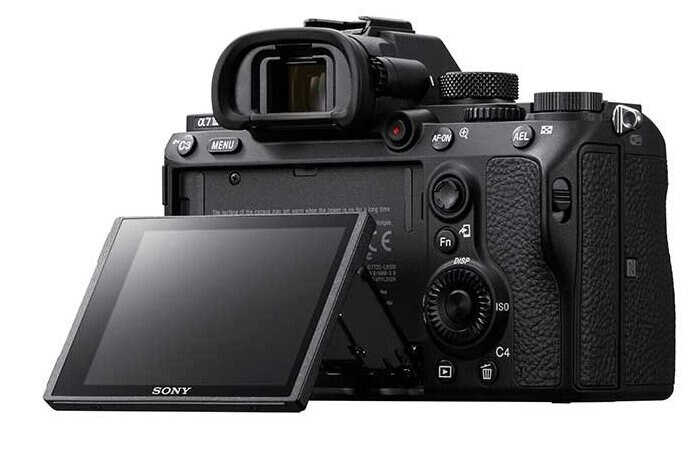 Czarny aparat Sony z widokiem z tyłu, z otwartym ekranem. Widoczne przyciski i elementy sterujące.
