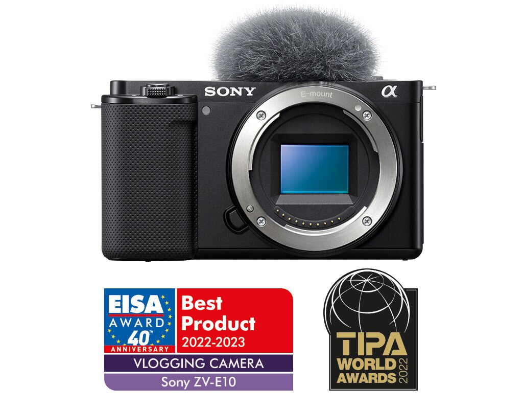 Czarny aparat Sony z mikrofonem i odznakami nagród. Białe tło.