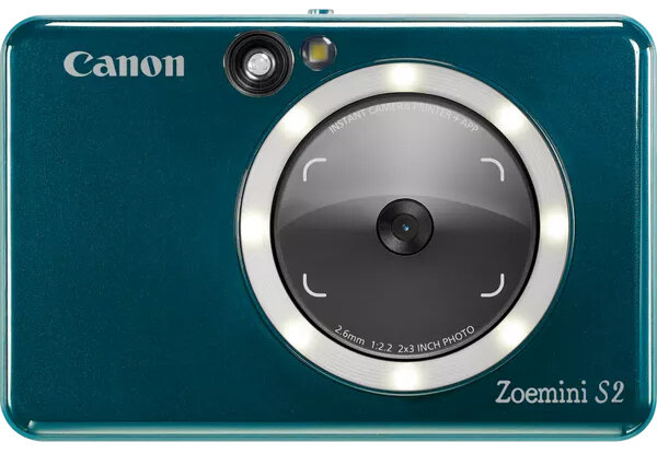 Turkusowy aparat Canon Zoemini S2 z białą obwódką wokół obiektywu i lampą błyskową.