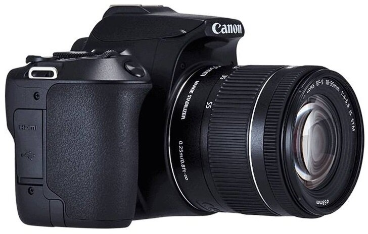 Czarny aparat Canon na białym tle, obiektyw skierowany w prawo.