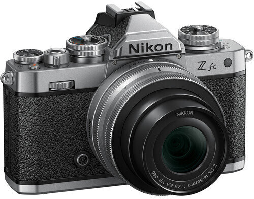 Srebrny aparat Nikon z czarnym uchwytem i obiektywem. Widoczne logo Nikon.