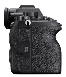 Widok z boku czarnego aparatu pokazujący pokrętła, przyciski i teksturowany uchwyt.