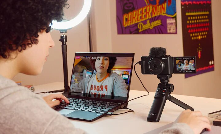 Osoba korzystająca z laptopa, przesyłająca strumieniowo wideo, z kamerą i oświetleniem.