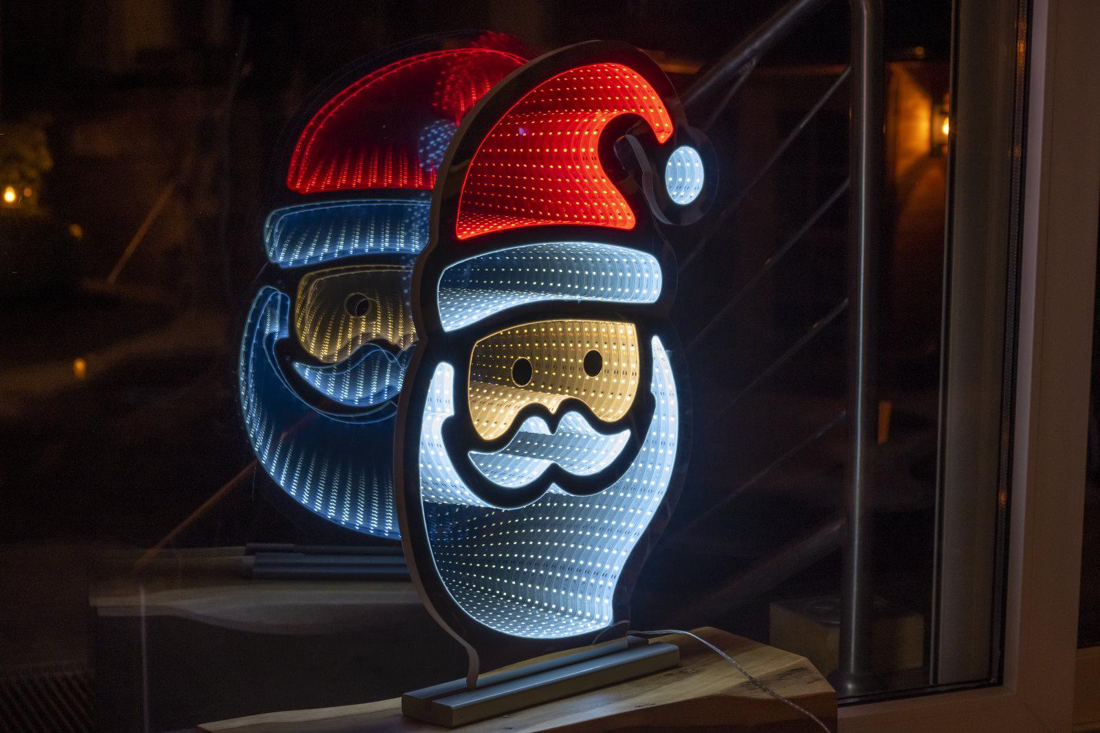 Weihnachtsdekoration. Weihnachtsmann mit unendlichen Spiegeleffekten. Lichter sind rot, weiß und blau.
