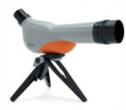 Luneta na małym statywie. Luneta jest szara i pomarańczowa. Czarne nogi statywu.