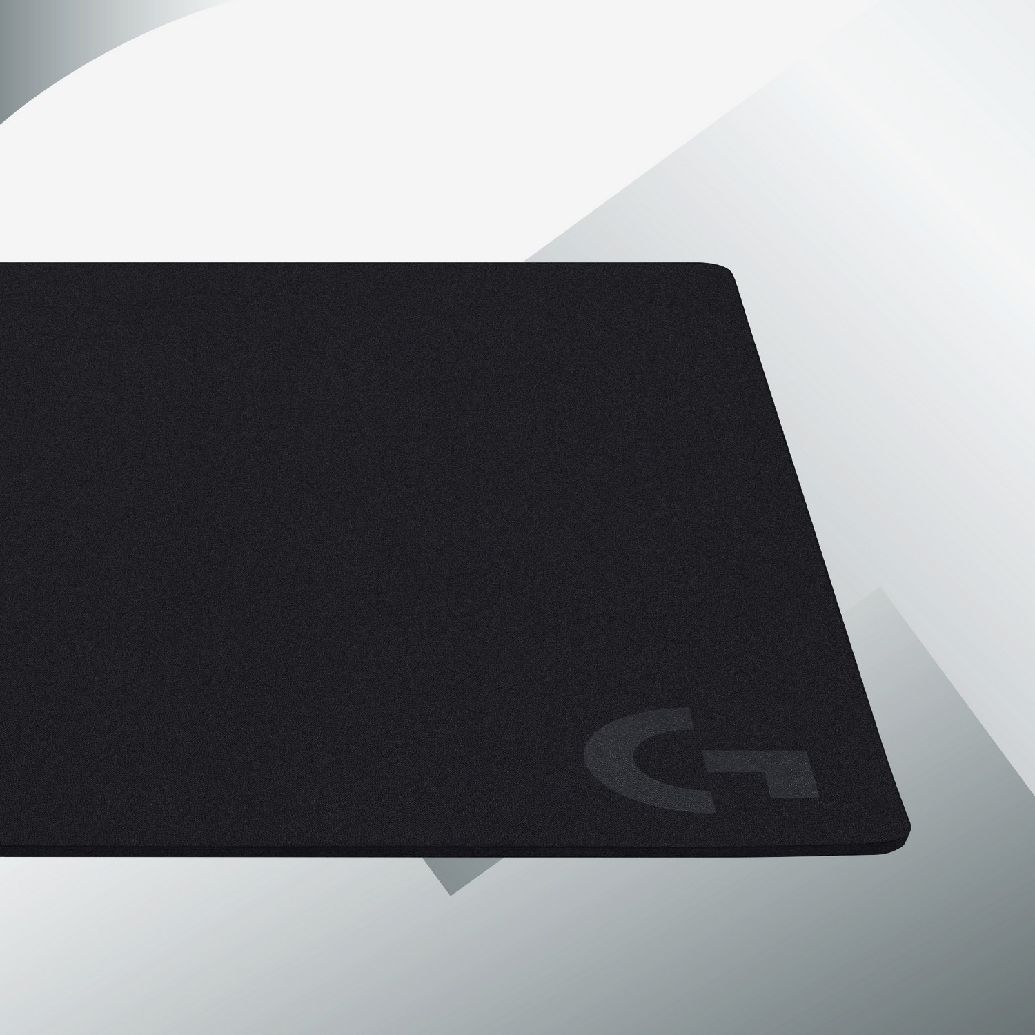 Un tapis de souris noir avec un logo 'G' gris foncé dans le coin inférieur droit.