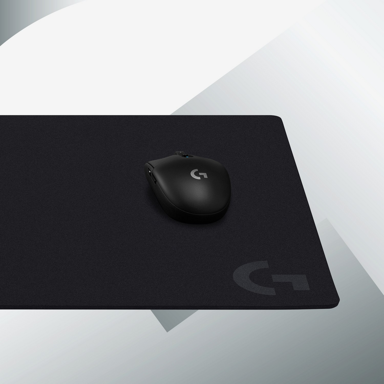 Souris noire sur tapis de souris noir. Fond gris et blanc.
