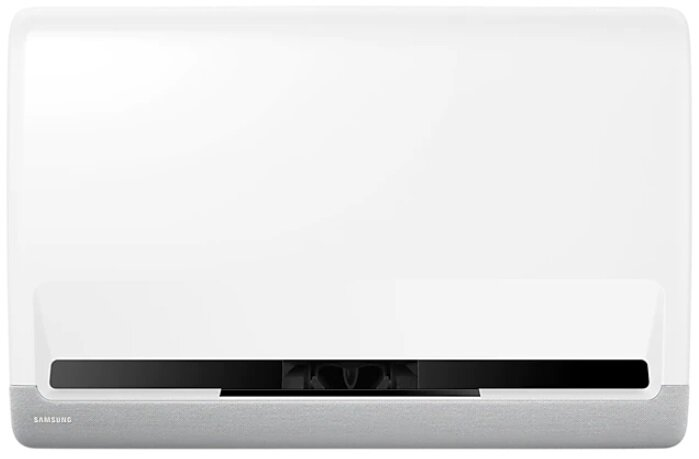 Biały projektor Samsung, z szarym dołem i czarnym przodem. Jest umieszczony na białej powierzchni.
