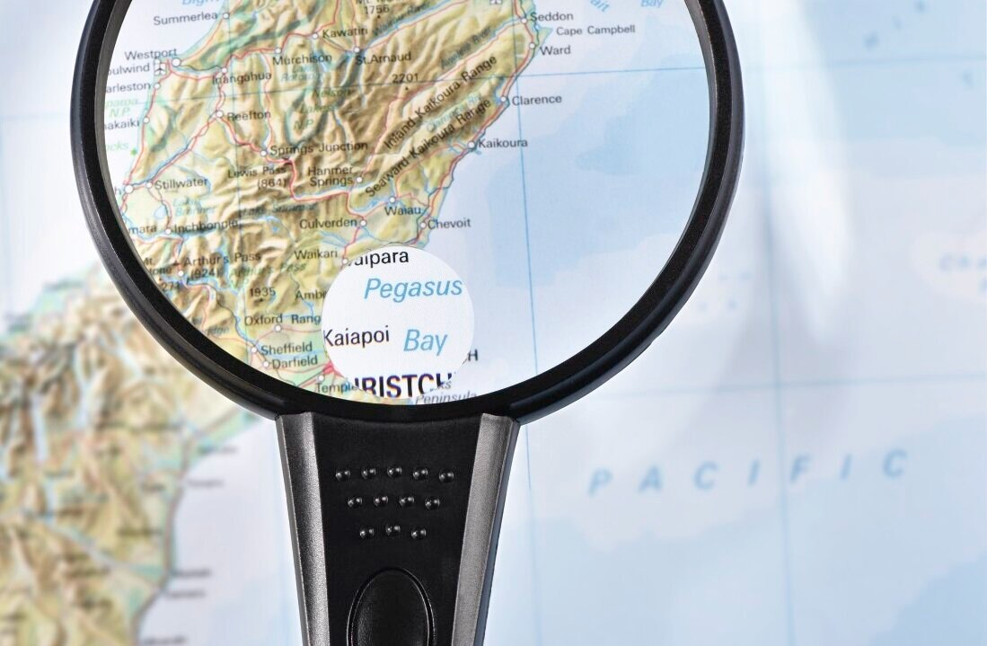 Lupa nad mapą, skupiająca się na lokalizacji.