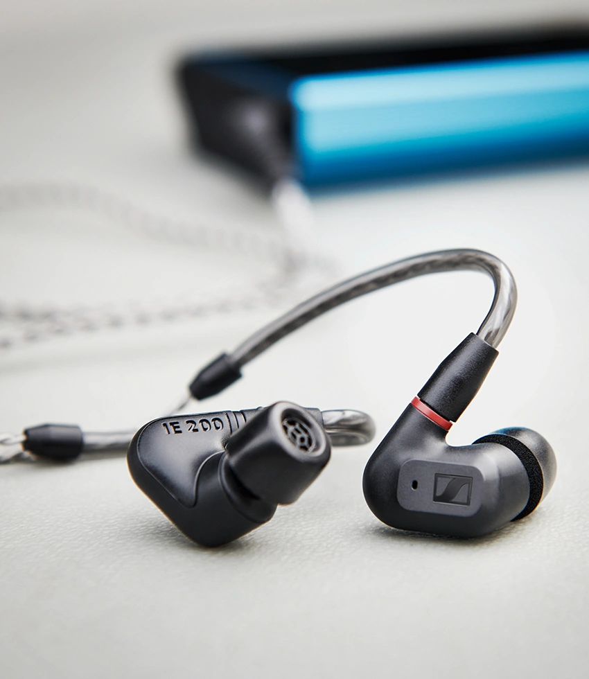 In-Ear-Kopfhörer, schwarz und grau, mit Kabel. Der Kopfhörer ist im Fokus, Hintergrund unscharf.