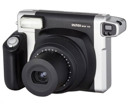 Czarno-srebrny aparat Instax Wide 300. Lampa błyskowa, obiektyw i przyciski widoczne na białym tle.