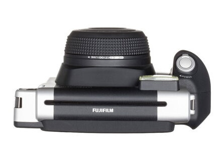 Czarny i srebrny aparat, widok z góry, obiektyw do góry, białe tło.