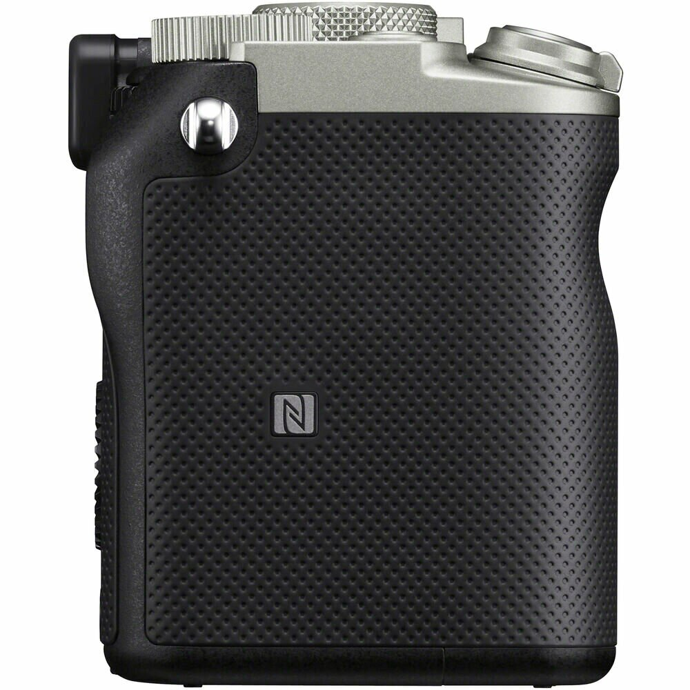 Aparat, widok z boku. Obudowa czarna z teksturowanym uchwytem. Góra srebrna.