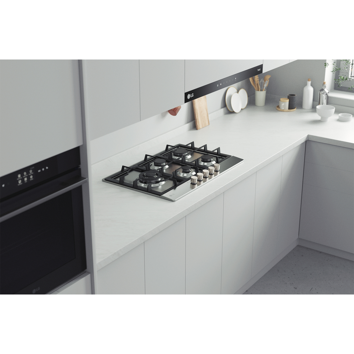 Cucina con piano cottura a gas sul piano di lavoro. Sopra, una cappa e a sinistra, un forno a incasso. Mobili grigio chiaro.