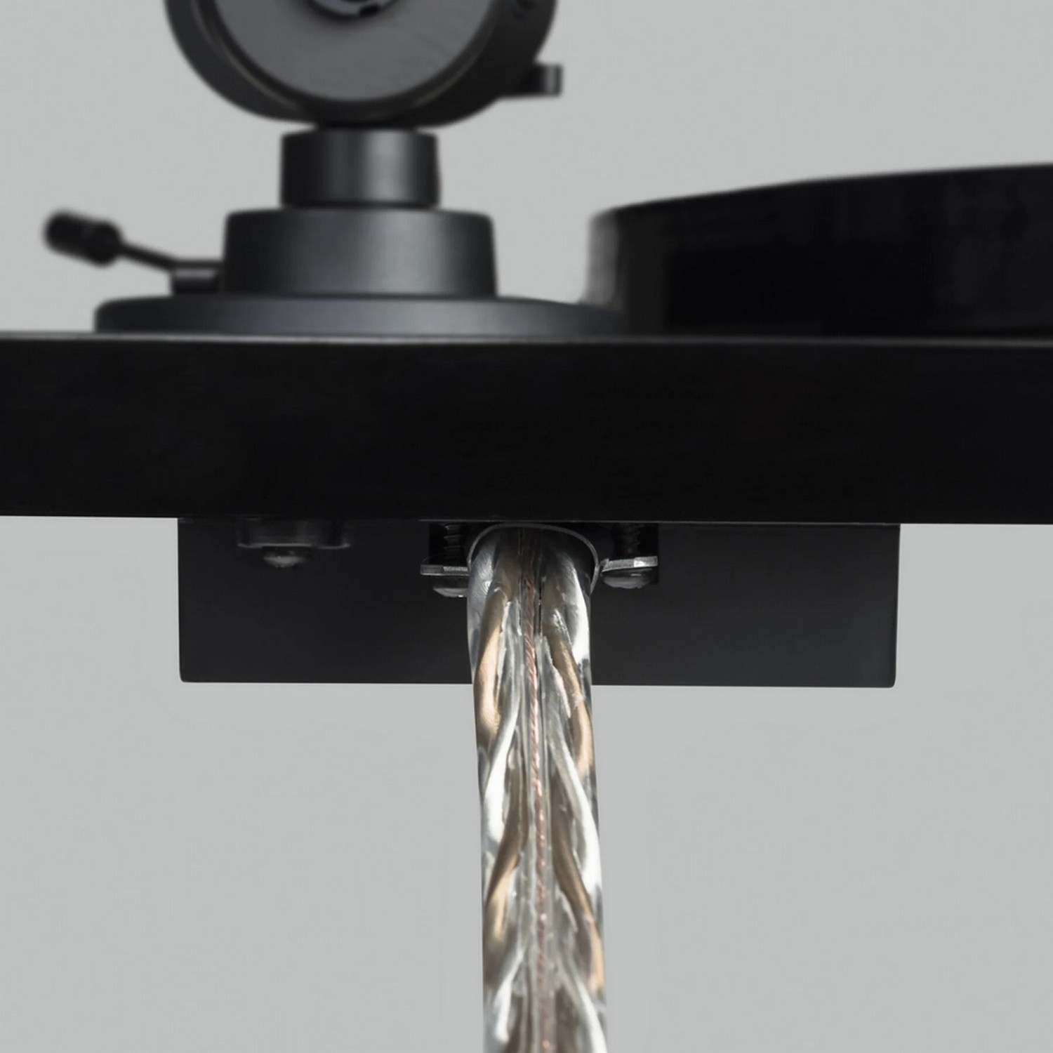 Close-up van een platenspeler met transparante plastic buis, zwarte basis.