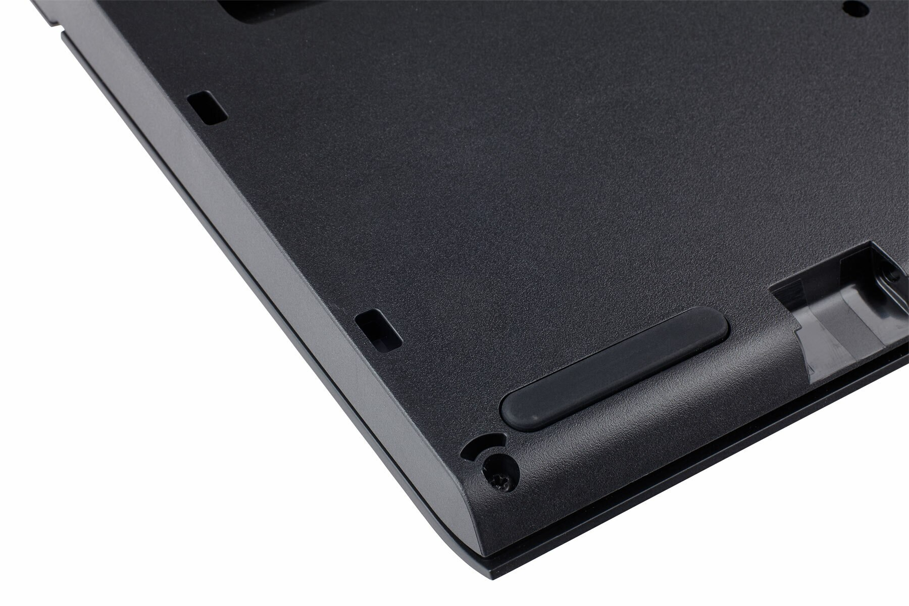 Spód czarnej klawiatury z gumowymi nóżkami i szczegółami śrub.