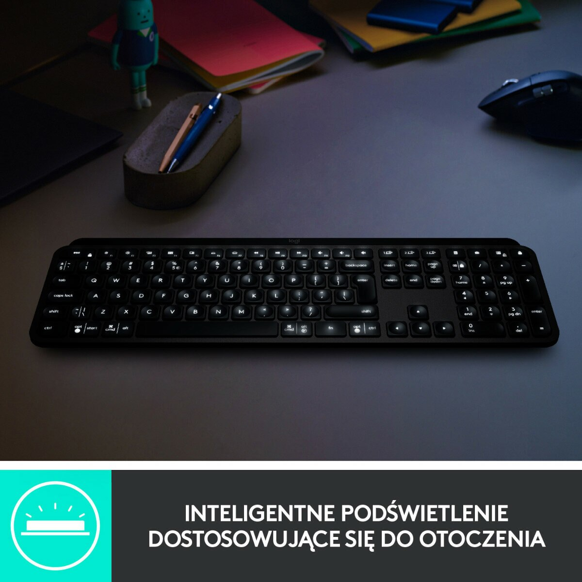 Czarna klawiatura z podświetlanymi klawiszami. Tło jest ciemne, ze stołem i przedmiotami.