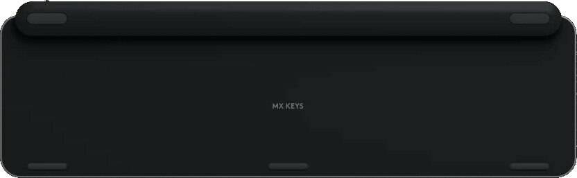 Czarny spód klawiatury z napisem 'MX KEYS' i gumowymi nóżkami.