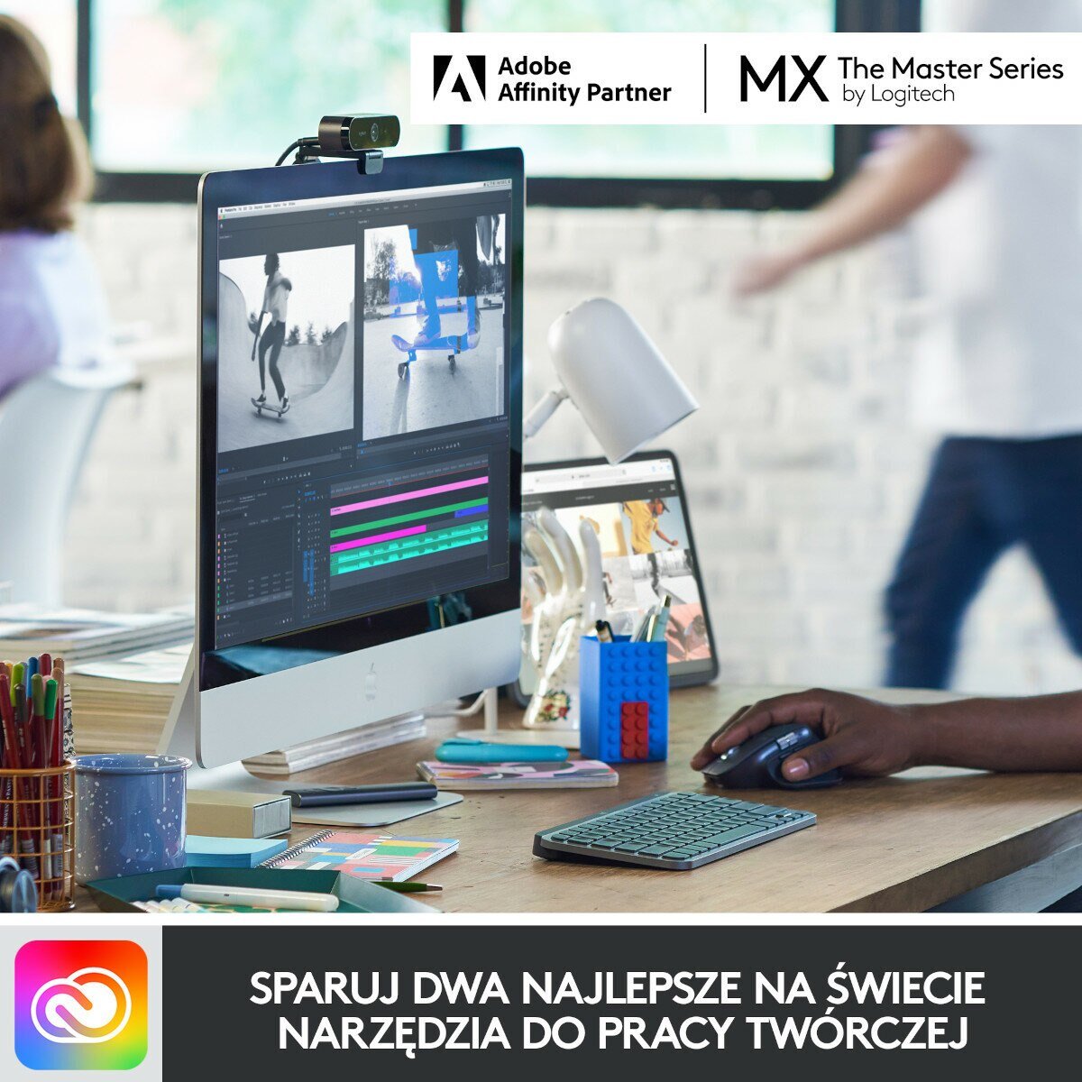 Osoba edytująca na monitorze z akcesoriami na drewnianym biurku.