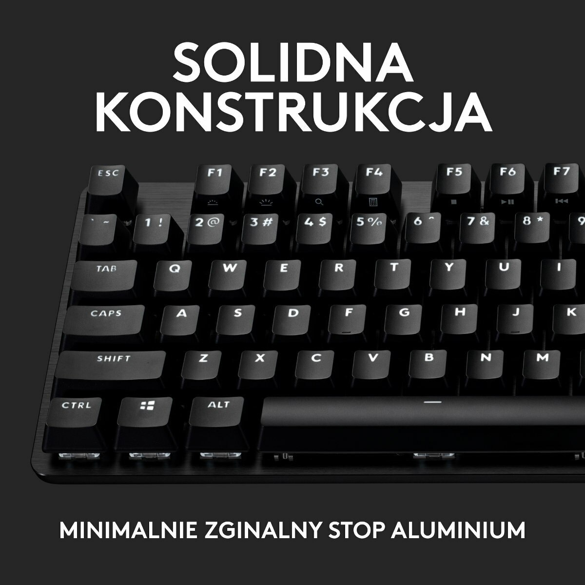 Zbliżenie czarnej klawiatury z białymi nakładkami klawiszy, widoczny napis 'SOLIDNA KONSTRUKCJA'.