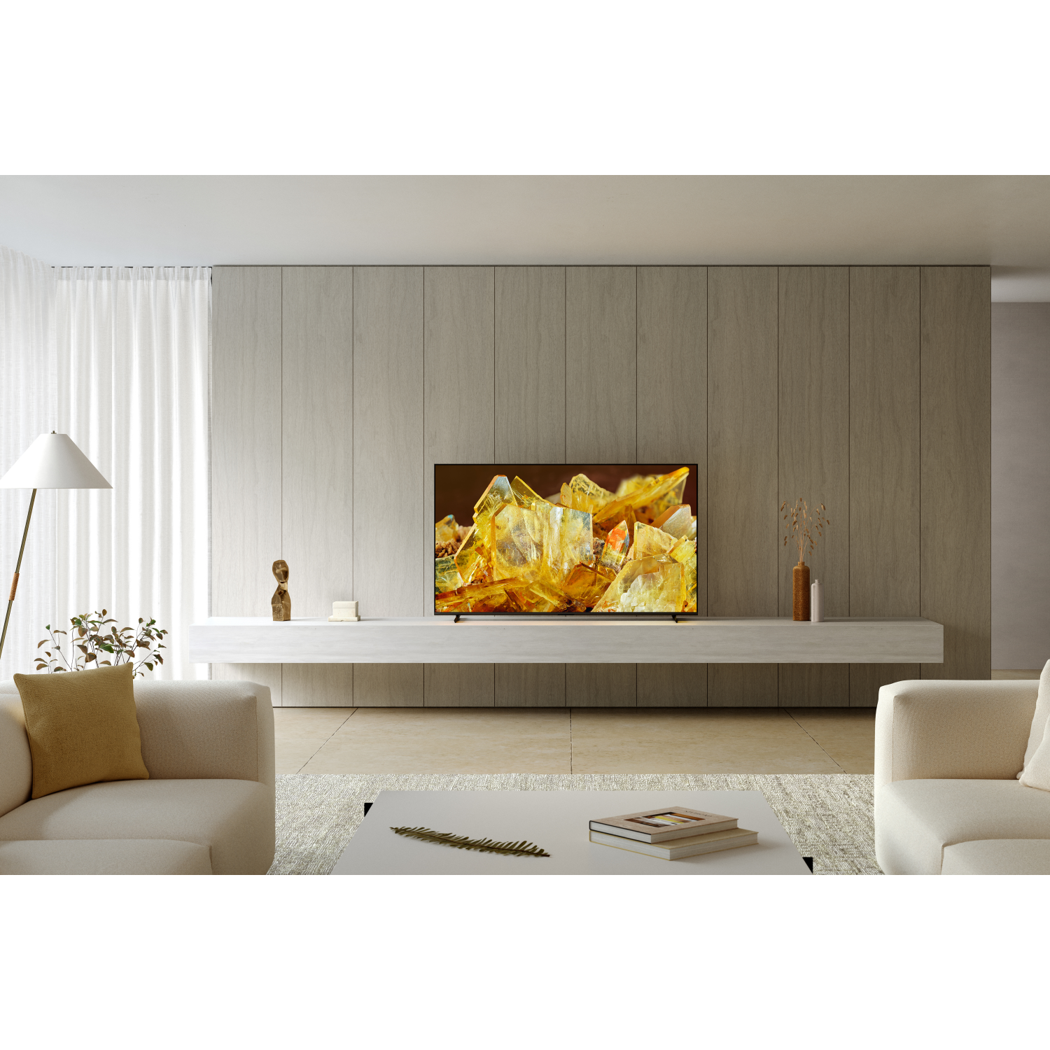 Modern living room with a TV on a wall. White sofa and table. Bright interior.