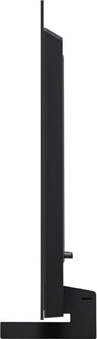 Vue latérale d'une TV noire sur un support, montrant le profil fin.
