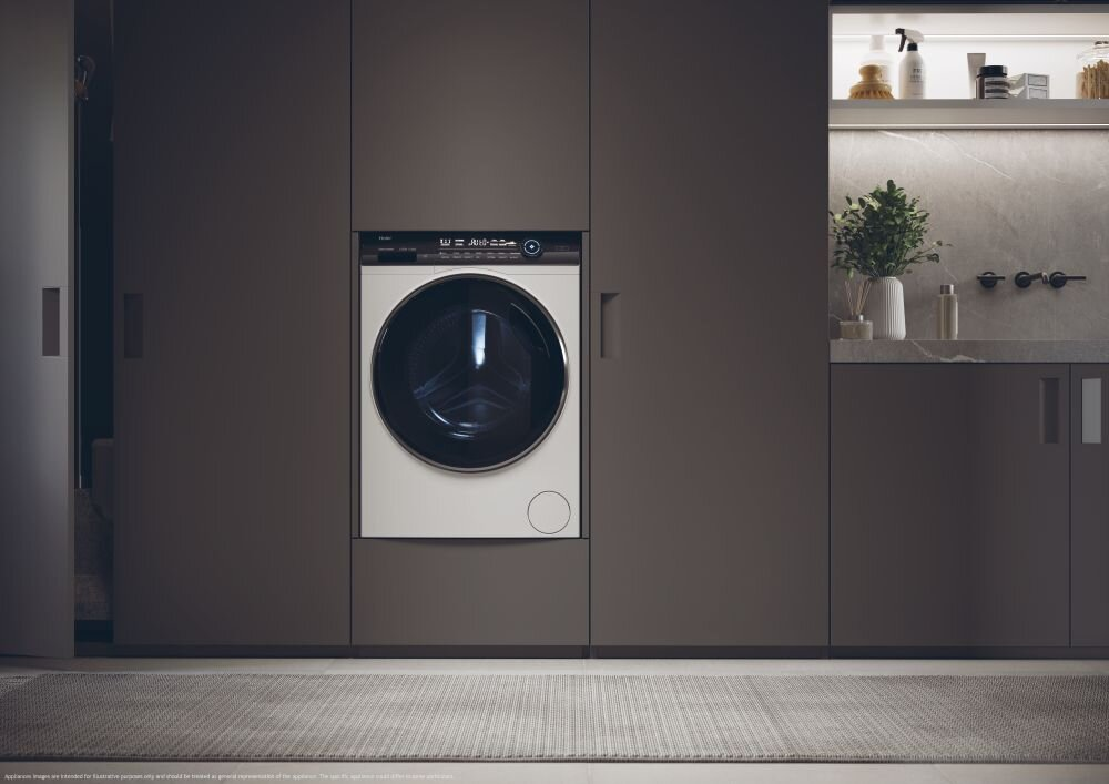 Nowoczesna pralnia z pralką w zabudowie w ciemnobrązowych szafkach. Dywan na podłodze.