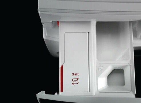 Zbliżenie szuflady na detergent, pokazujące komorę na sól ze strzałkami.