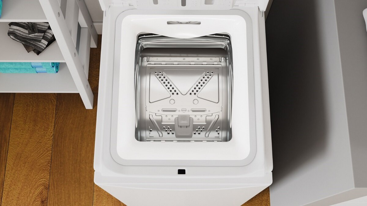 Widok z góry na białą pralkę. Widoczne wnętrze bębna, srebrna ramka.