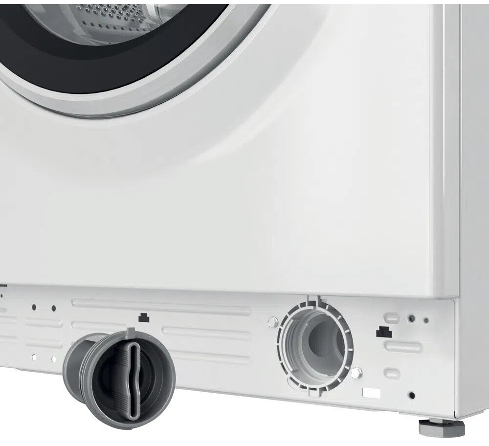 Zbliżenie dolnej części białej pralki pokazujące przyłącze węża odpływowego.