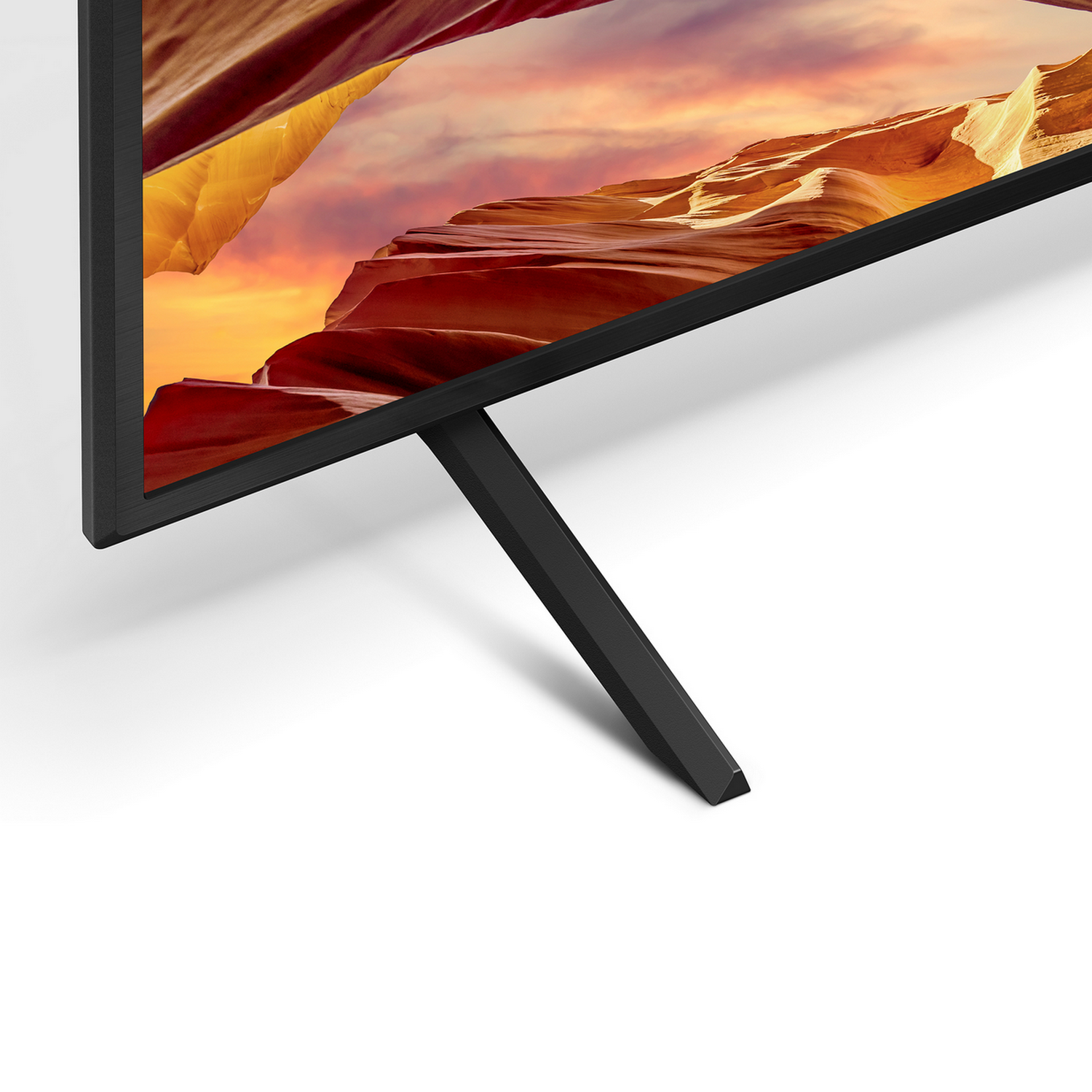 Een close-up van een tv met een zwart frame en een eenvoudige zwarte standaard.
