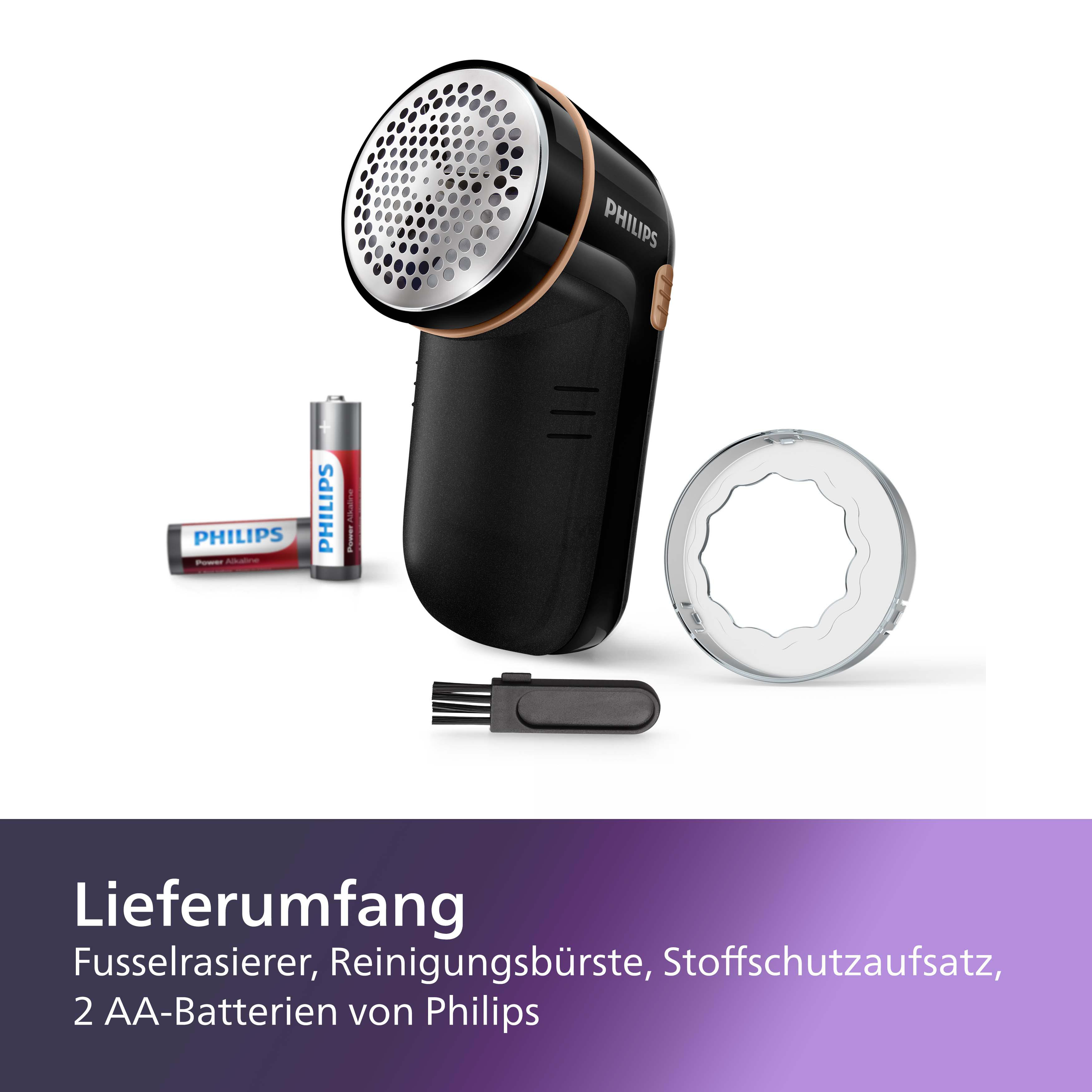 Ein schwarzer und goldfarbener Philips Stoffrasierer mit Zubehör, einschließlich Batterien und Bürste.
