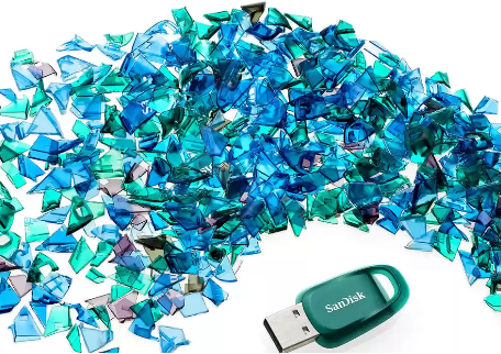 Une collection d'éclats bleus et verts dispersés près d'une clé USB verte.