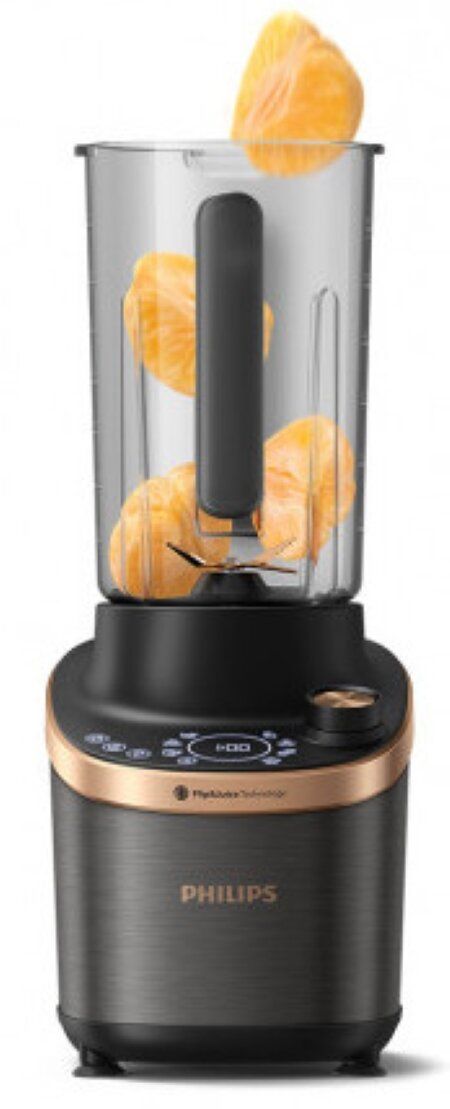 Blender z pomarańczami w środku, czarną podstawą, przezroczystym dzbankiem i złotym wykończeniem.