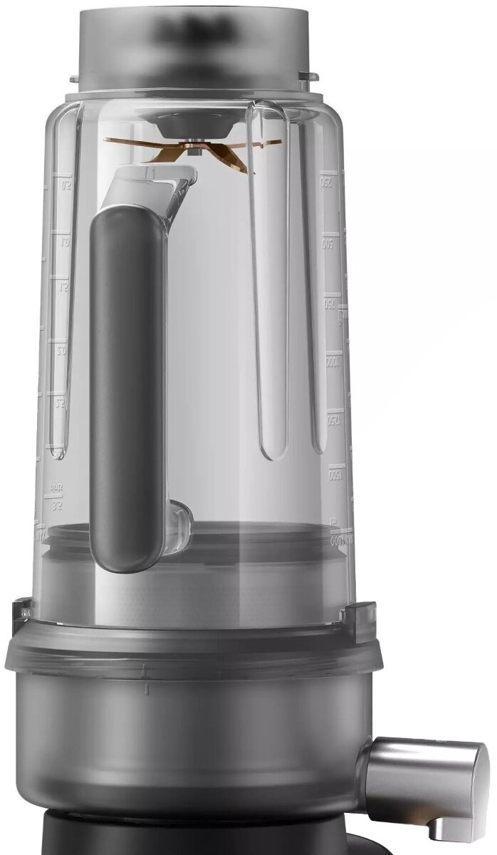 Zbliżenie przezroczystego blendera. Ma uchwyt, ostrze i kilka oznaczeń.