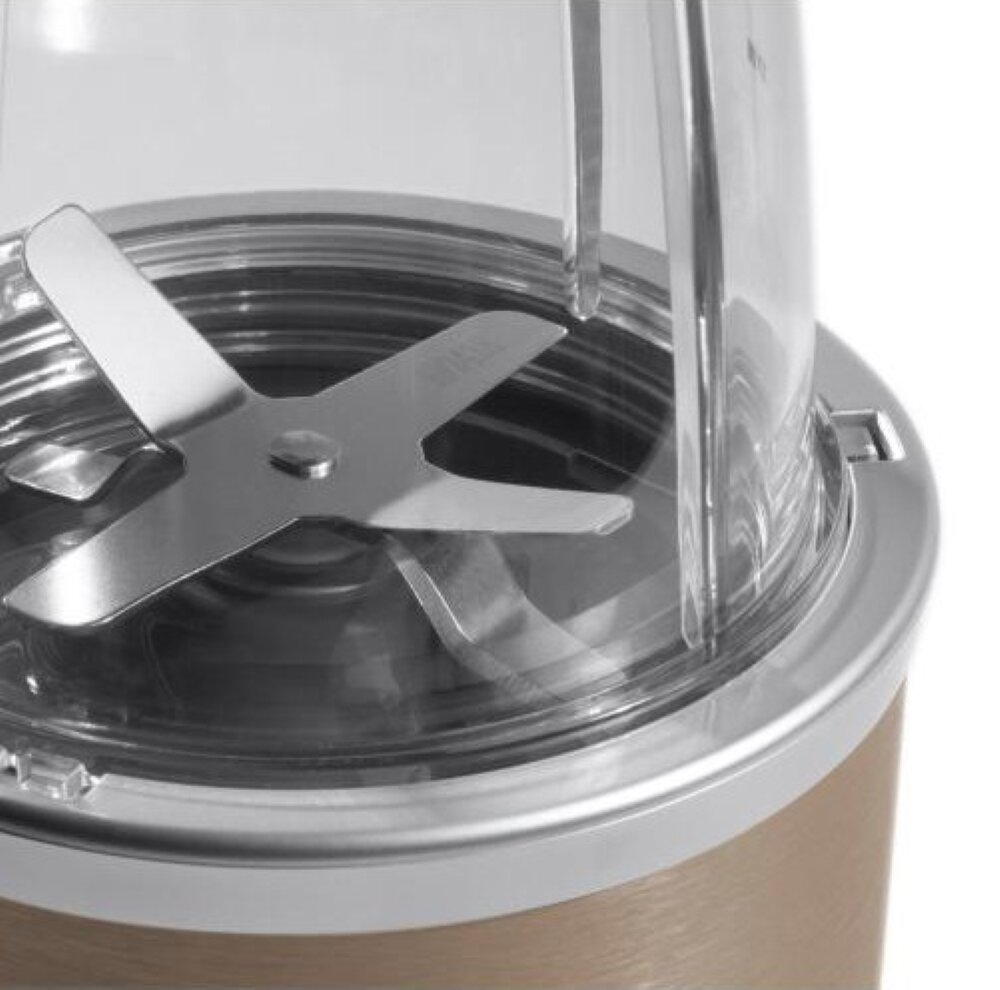 Zbliżenie ostrza blendera w przezroczystym pojemniku, na brązowej podstawie.