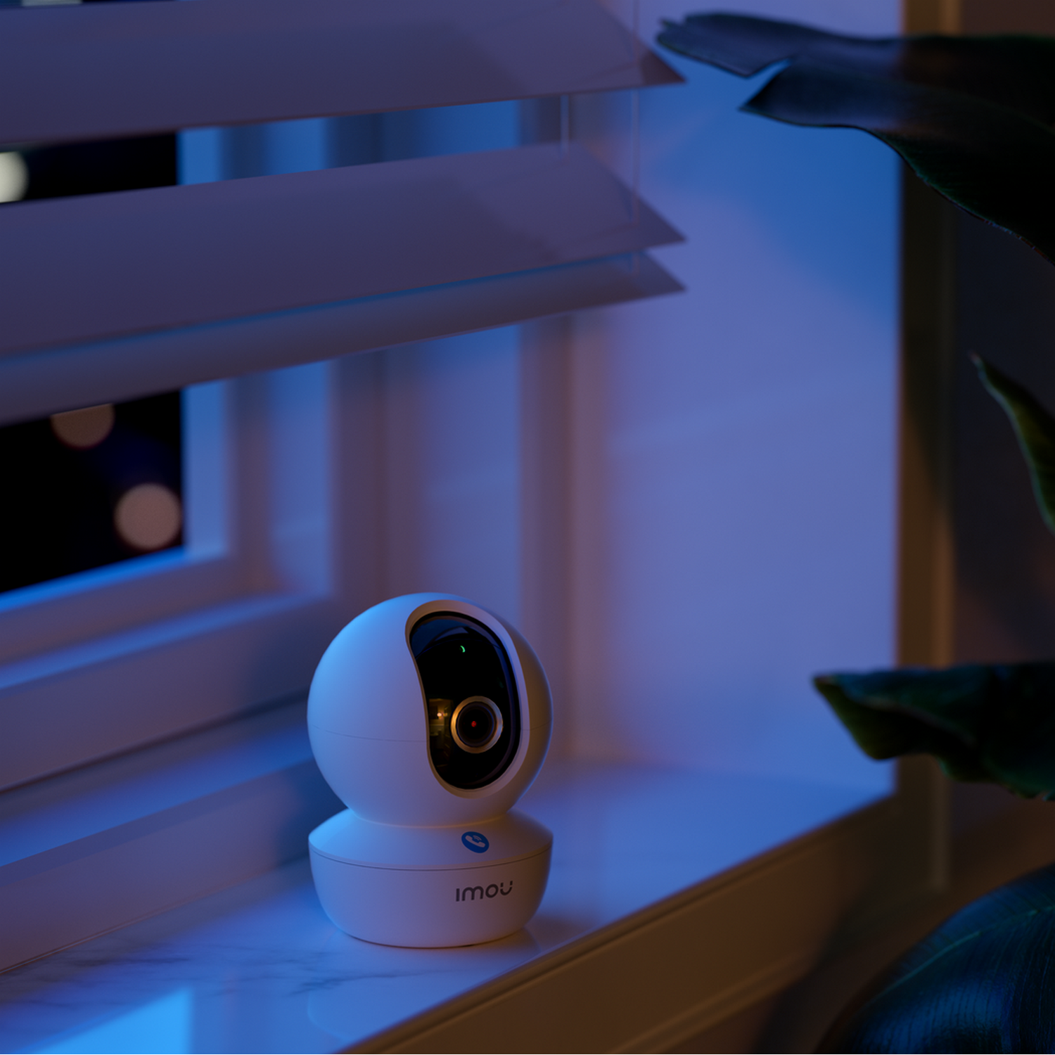 A white security camera on a windowsill, with a window and a dark night scene.