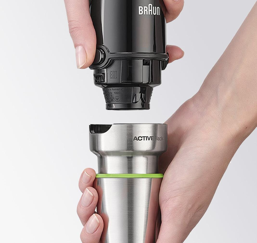 Ręce łączące czarne ostrze blendera ręcznego z obudową silnika.