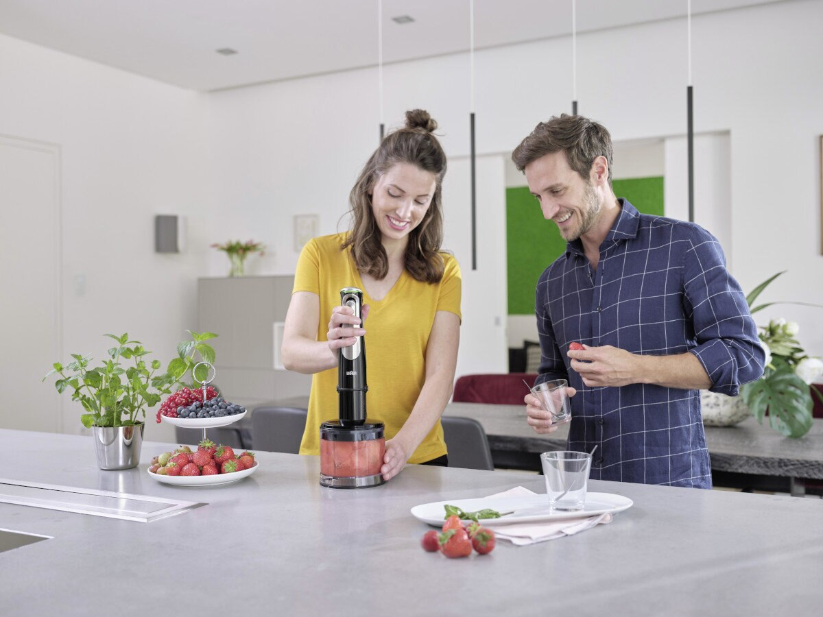 Para robiąca koktajl za pomocą blendera w nowoczesnej kuchni.