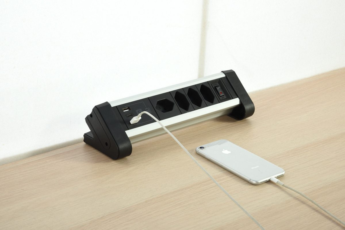 Eine Steckdosenleiste mit USB- und Steckdosen. Ein Telefon ist angeschlossen.