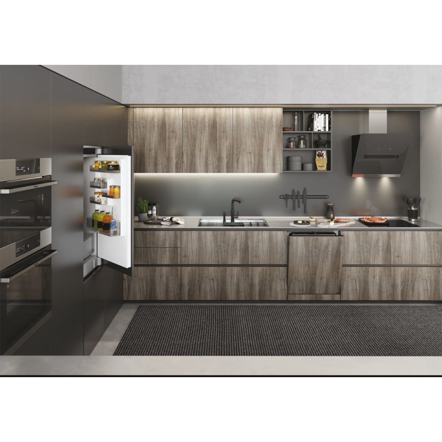 Cucina moderna con mobili in legno, elettrodomestici e piano di lavoro grigio. Frigorifero aperto a sinistra.