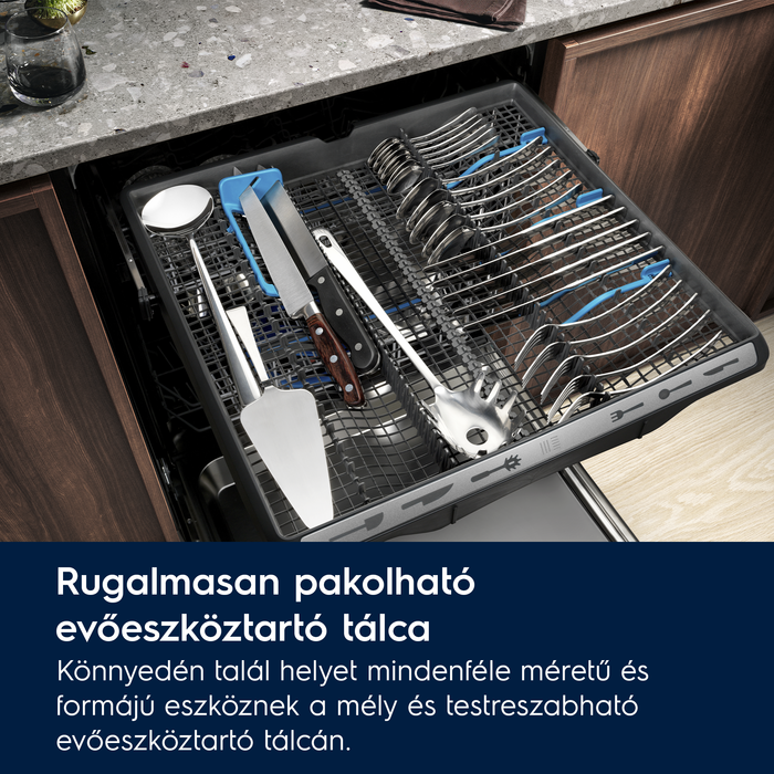 Mosogatógép fiók evőeszközökkel, evőeszközökkel és rendezett konyhai eszközökkel.