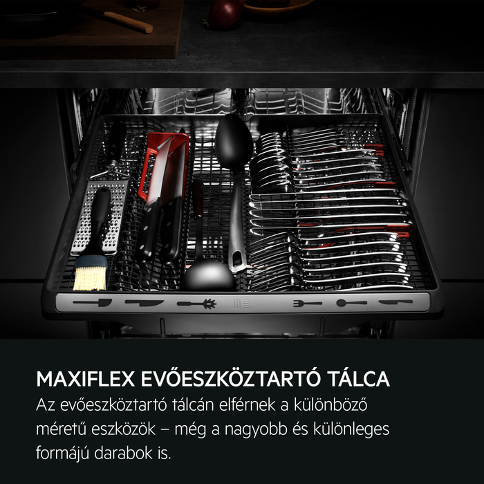 Mosogatógép fiók evőeszközökkel és eszközökkel. Egy fekete fiók különféle konyhai eszközökkel.