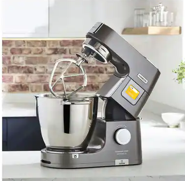 Szürke Kenwood konyhai mixer felemelt karral és rozsdamentes acél tál.