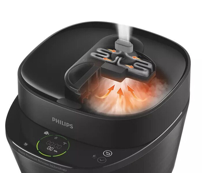 Zbliżenie czarnego szybkowaru. Widoczna para i elementy wewnętrzne.