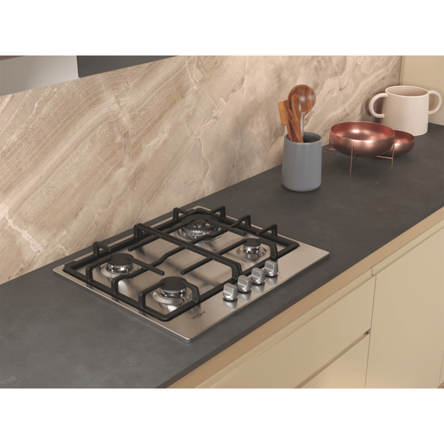Piano cottura a gas in acciaio inox con quattro fuochi e manopole. Lo sfondo è una cucina.