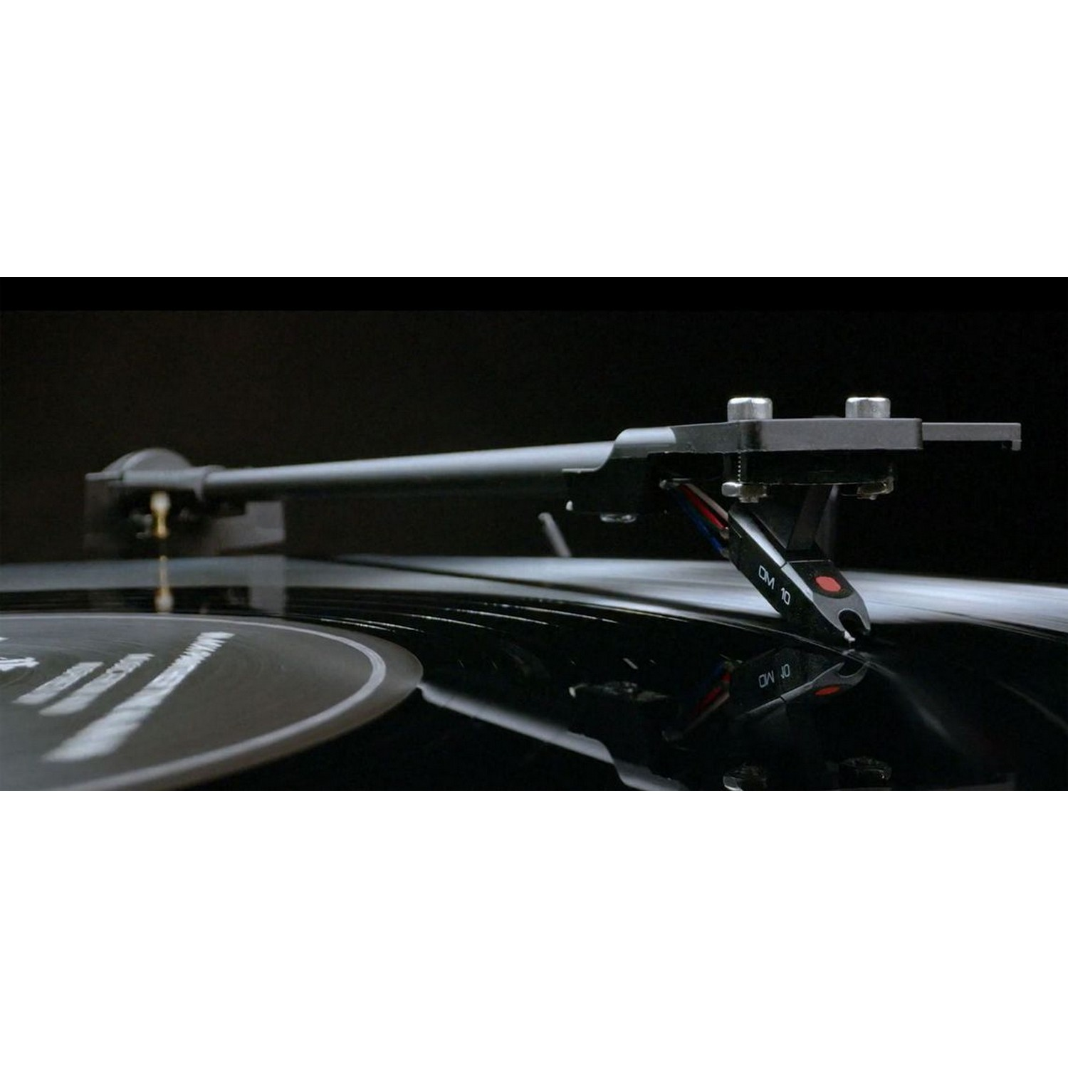 Platine vinyle avec un bras noir et un disque noir. L'aiguille est visible.