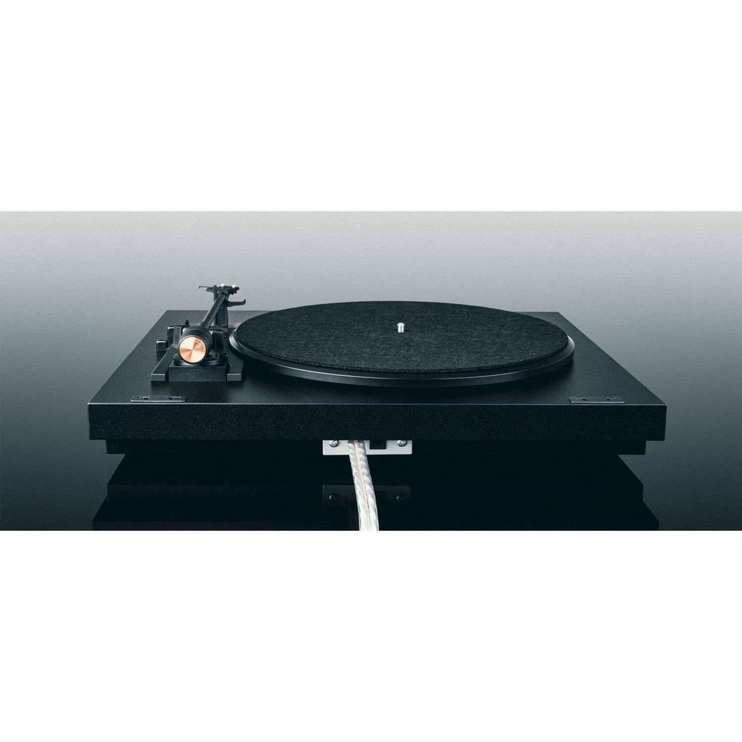 Une platine vinyle noire avec un disque vinyle. La platine est posée sur une surface noire.