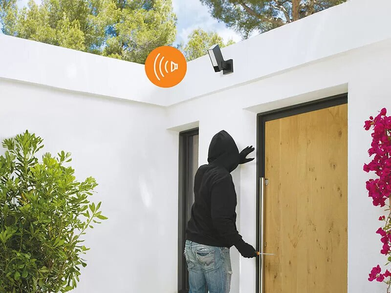 Złodziej próbuje włamać się do domu. Widoczne światło bezpieczeństwa z falami dźwiękowymi.