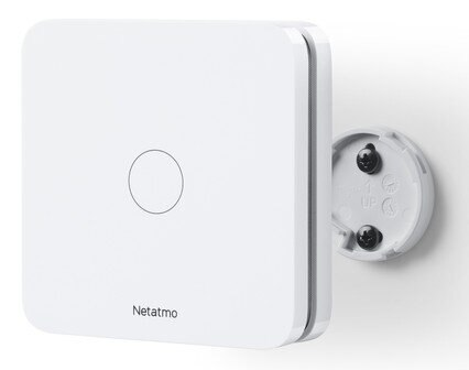 Białe urządzenie smart home jest zamontowane na ścianie z okrągłym przyciskiem i mocowaniem śrubowym.